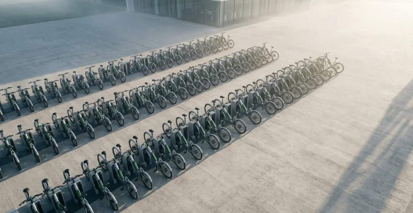 Vue aérienne d'une flotte de vélos électriques d'entreprise alignés dans un parking moderne et sécurisé